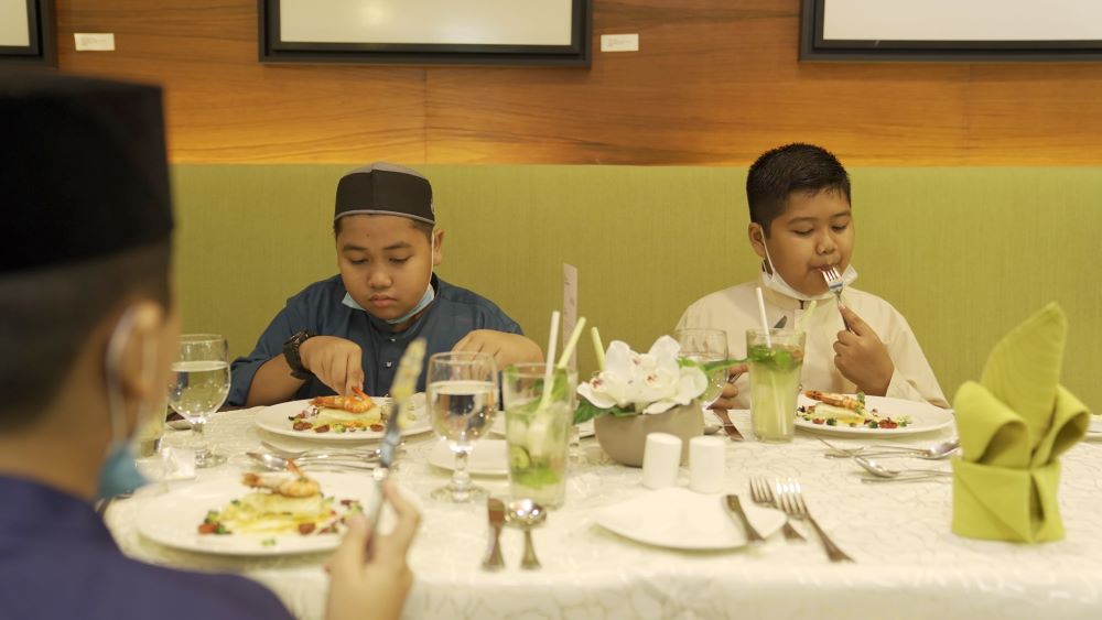 Two boys enjoying their meals.